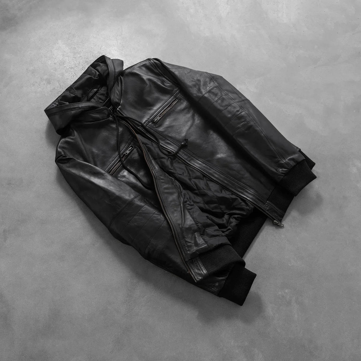 
På model:  Bouncer Biz Black Leather Hooded Bomber Jacket på model med naturligt fald i dagslys