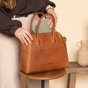 Styled Fit Perspective of Marsala Full-Grain Leather Handbag til Kvinder on Model - Natural Daylight Drape